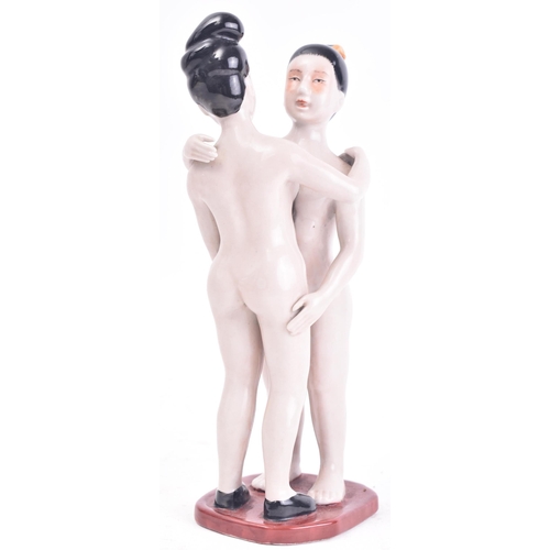 23 - A Chinese Oriental porcelain erotic figure depicting male & female figure embracing each other. Rais... 