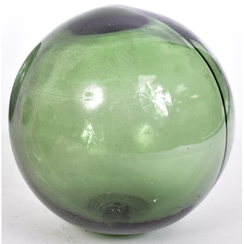 239 - Glass - a selection of four early 20th century hand-blown green glass fishing floats / witch balls. ... 