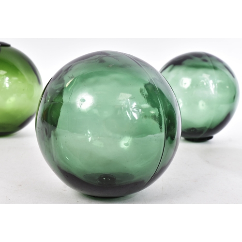 239 - Glass - a selection of four early 20th century hand-blown green glass fishing floats / witch balls. ... 