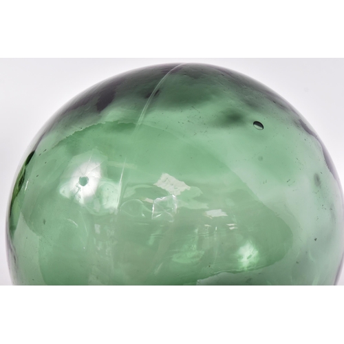 239 - Glass - a selection of four early 20th century hand-blown green glass fishing floats / witch balls. ... 