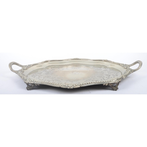 241 - An oversized 19th century large silver plated salver tray. The tray being raised on s-scroll termina... 