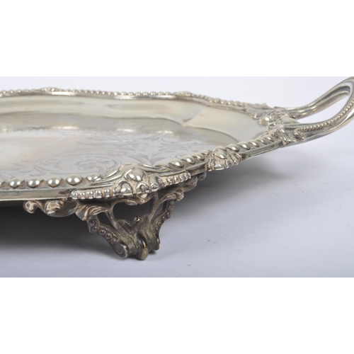 241 - An oversized 19th century large silver plated salver tray. The tray being raised on s-scroll termina... 