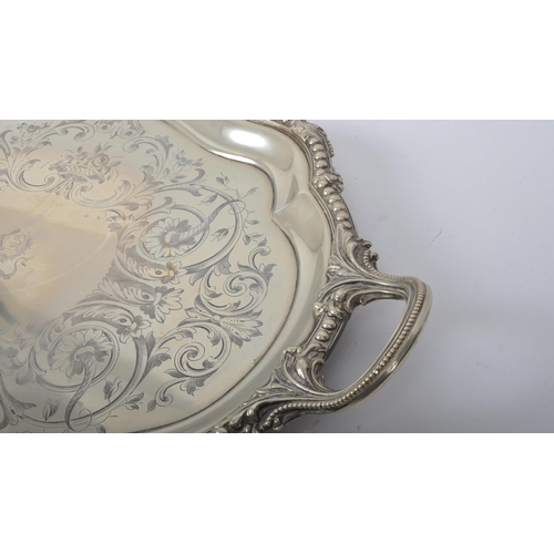 241 - An oversized 19th century large silver plated salver tray. The tray being raised on s-scroll termina... 