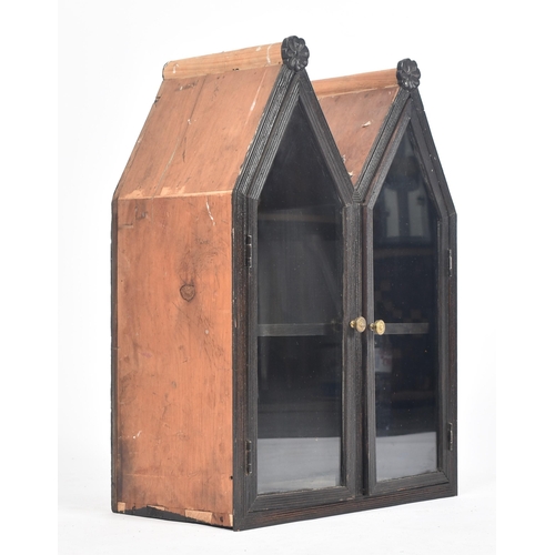 393 - An early 20th century pine gothic style hanging cabinet. The cabinet having twin arched tops with ca... 