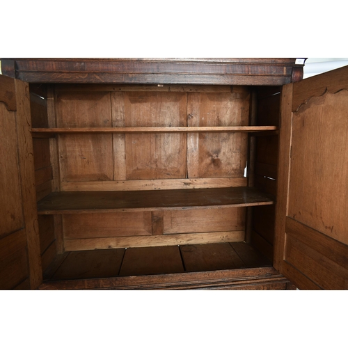 425 - An 18th century George III oak country house housekeeper's cupboard / linen press. The cupboard comp... 