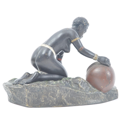 426 - An early 20th century cold painted bronze figure of a kneeling African tribal woman filling a pot wi... 