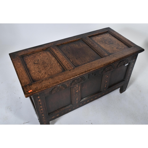 454 - A 17th century inlaid oak coffer / blanket box / chest. The coffer having a hinged top over a carved... 