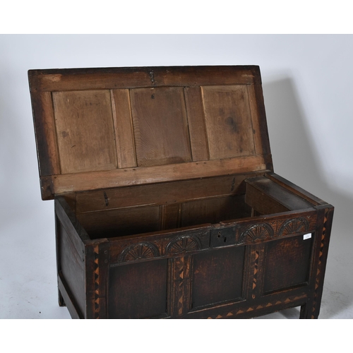 454 - A 17th century inlaid oak coffer / blanket box / chest. The coffer having a hinged top over a carved... 