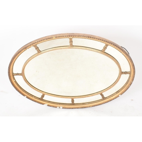 47 - A 19th century Victorian oval giltwood and gesso mirror. The mirror having a gilt frame with gadroon... 