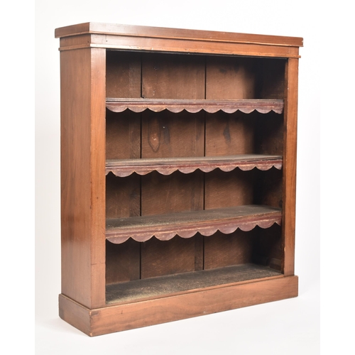 49 - A 19th century Victorian walnut open upright library bookcase. The bookcase having an overhanging to... 