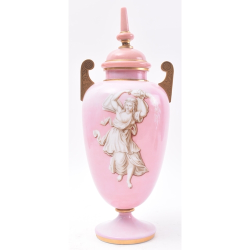 647 - A late 19th Century French opaline pink glass urn. The urn having a finial topped cover with bulbous... 