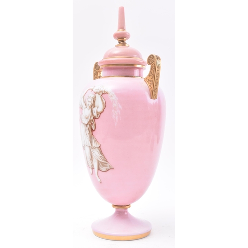 647 - A late 19th Century French opaline pink glass urn. The urn having a finial topped cover with bulbous... 