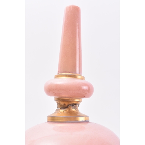 647 - A late 19th Century French opaline pink glass urn. The urn having a finial topped cover with bulbous... 