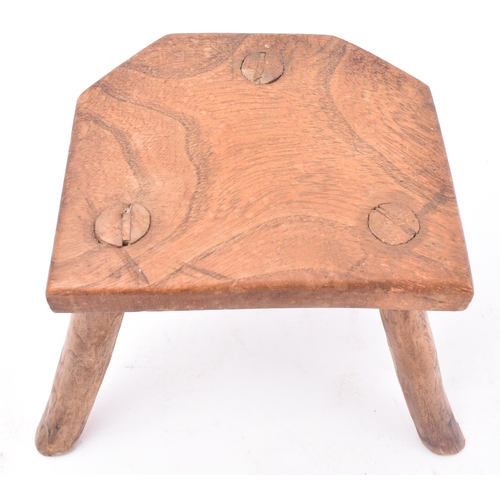 657 - A 19th century miniature elm stool. The stool having a shaped top supported by three elm supports. M... 