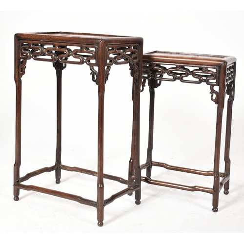 669 - A 19th century Chinese Oriental padauk wood nest of two graduating tables. Each table having a reces... 