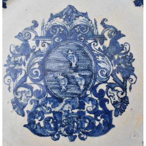 67 - An early 18th century French Louis XIV Lille earthenware armorial plate. The plate in blue and white... 