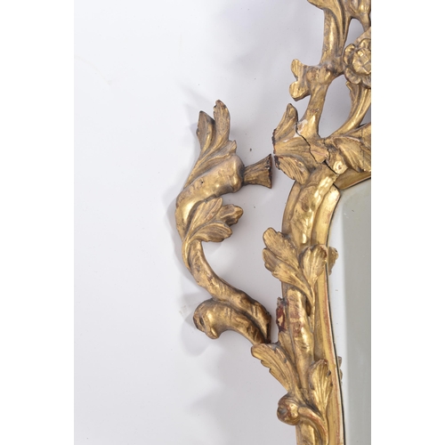 68 - An 18th century George II giltwood and gesso carved mirror. The mirror having a central mirror plate... 