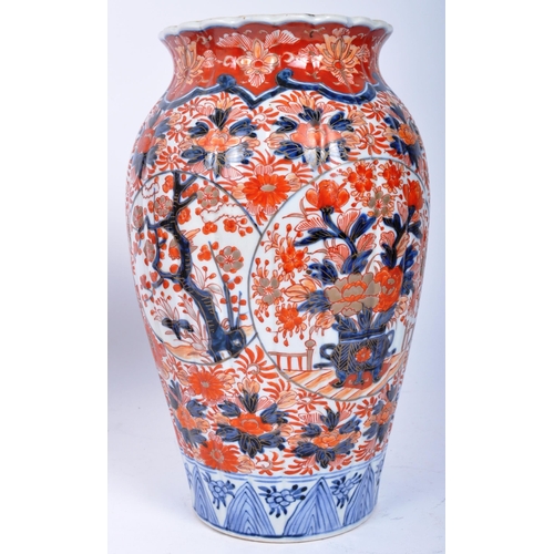 298 - A pair of late 19th century Japanese Imari urn vases. The vases featuring blue and red floral motifs... 