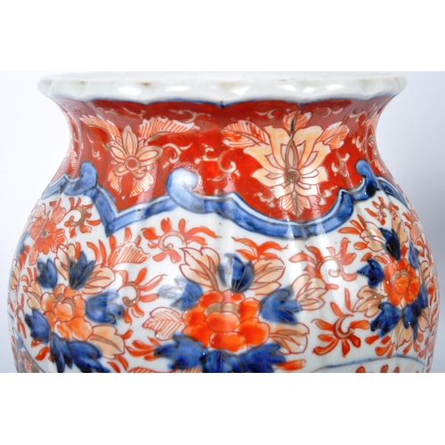 298 - A pair of late 19th century Japanese Imari urn vases. The vases featuring blue and red floral motifs... 