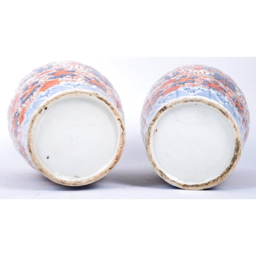 298 - A pair of late 19th century Japanese Imari urn vases. The vases featuring blue and red floral motifs... 