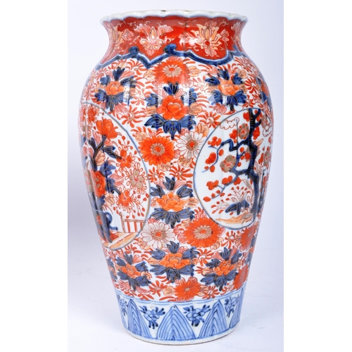 298 - A pair of late 19th century Japanese Imari urn vases. The vases featuring blue and red floral motifs... 