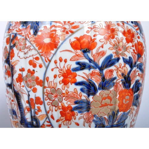 298 - A pair of late 19th century Japanese Imari urn vases. The vases featuring blue and red floral motifs... 