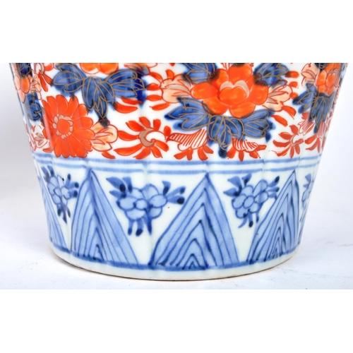 298 - A pair of late 19th century Japanese Imari urn vases. The vases featuring blue and red floral motifs... 