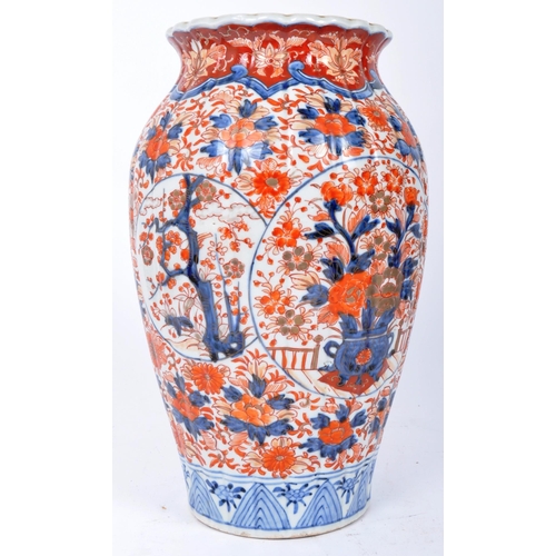 298 - A pair of late 19th century Japanese Imari urn vases. The vases featuring blue and red floral motifs... 