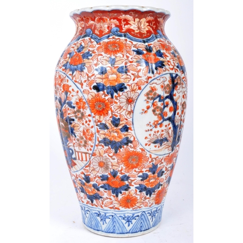 298 - A pair of late 19th century Japanese Imari urn vases. The vases featuring blue and red floral motifs... 