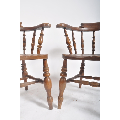 374 - A pair of Victorian 19th century beech and elm wood smokers bow captain's armchairs. The armchairs h... 