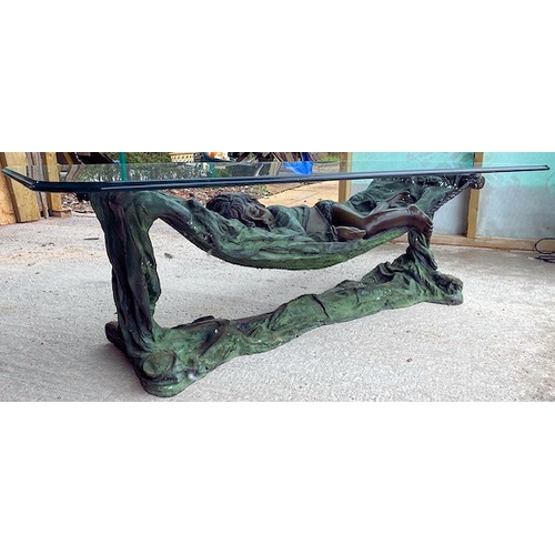 137 - A contemporary bronze worked coffee table in the form of a sleeping child resting in a cot / hammock... 