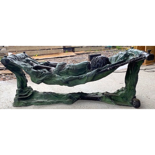 137 - A contemporary bronze worked coffee table in the form of a sleeping child resting in a cot / hammock... 