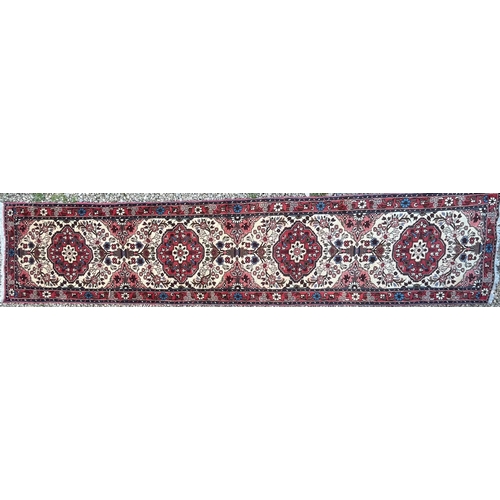 187 - An early 20th century North West Persian Islamic Rudbar hand woven floor runner rug having a series ... 