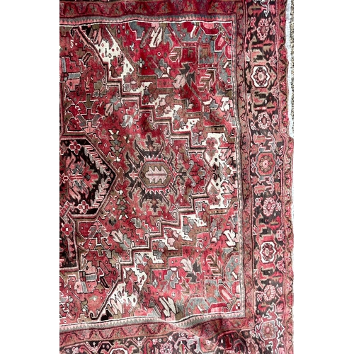 264 - A 19th century Central Persian Islamic Heriz hand woven floor carpet rug, having a central panel wit... 