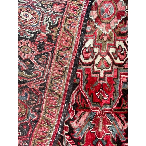 264 - A 19th century Central Persian Islamic Heriz hand woven floor carpet rug, having a central panel wit... 