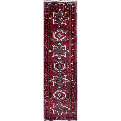 288 - An early 20th century North West Persian Islamic Heriz hand woven floor carpet runner rug having a c... 