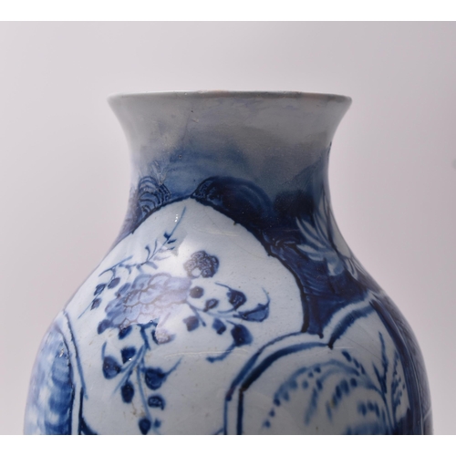 655 - A 19th century blue and white transfer and hand painted vase. The vase having a lipped rim with tape... 