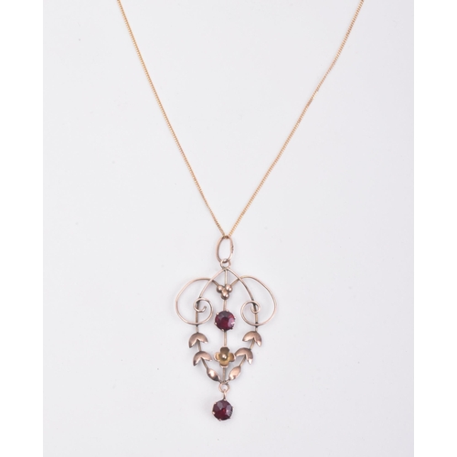 179 - An antique 9ct gold and garnet necklace pendant on a 375 marked chain. The pendant of open work scro... 