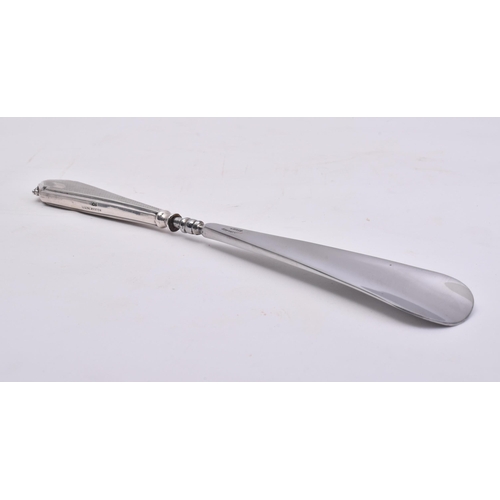 25 - A hallmarked silver handled stainless steel shoe horn. The main body of the shoe horn made from stai... 