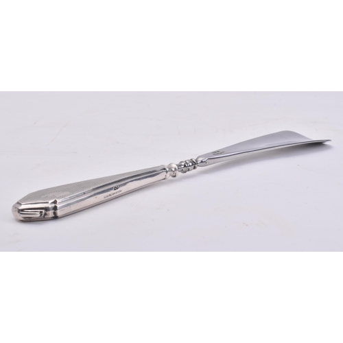 25 - A hallmarked silver handled stainless steel shoe horn. The main body of the shoe horn made from stai... 