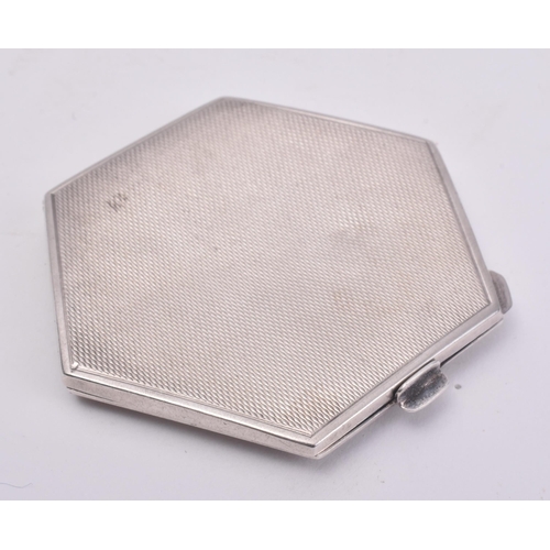 39 - A hallmarked silver compact mirror. The mirror of post war Art Deco style in hexagonal form with ste... 