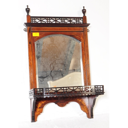 804 - An Edwardian mahogany wall hanging mirror with pierced under shelf and upper border with finial deco... 