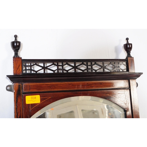 804 - An Edwardian mahogany wall hanging mirror with pierced under shelf and upper border with finial deco... 