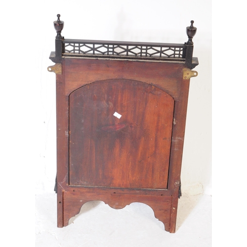 804 - An Edwardian mahogany wall hanging mirror with pierced under shelf and upper border with finial deco... 
