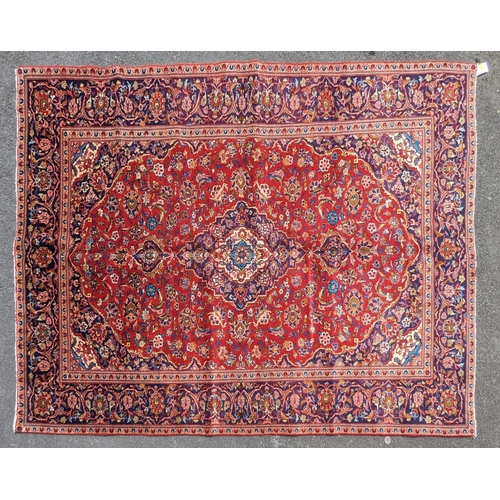 1023 - A 20th century central Persian kashan floor rug carpet. Having a large central medallion on a red gr... 