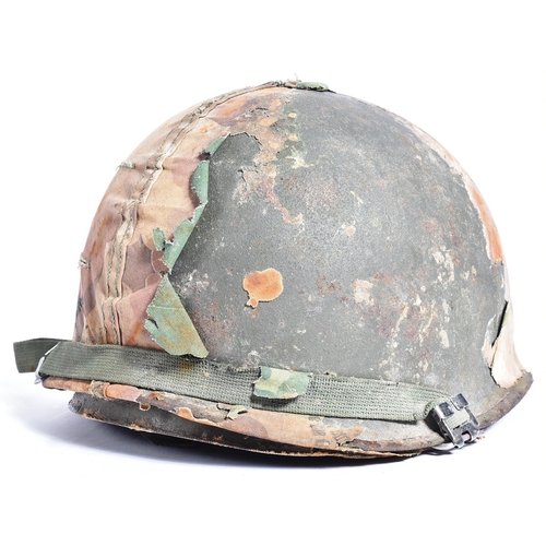 86 - A Vietnam War era US United States M1 steel combat helmet with camo cover. Swivel bale example with ... 