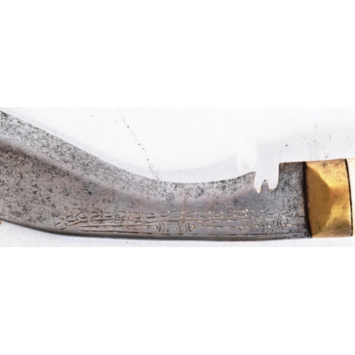 97 - An early 20th Century Tibetan Kukri knife. The carved bone handle inlaid with a brass lozenge to the... 