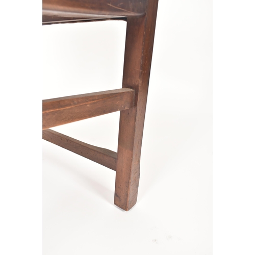 192 - An early 20th century Arts & Crafts oak and leather elbow chair. The chair having a curved leather u... 