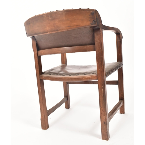 192 - An early 20th century Arts & Crafts oak and leather elbow chair. The chair having a curved leather u... 