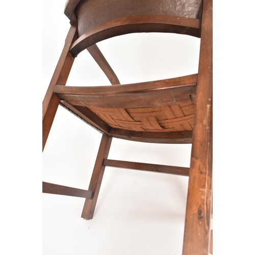 192 - An early 20th century Arts & Crafts oak and leather elbow chair. The chair having a curved leather u... 